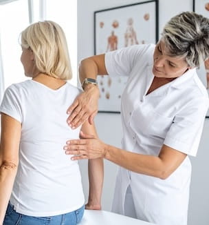 Thumbnail image of a female chiropractor examining a patient's spine.