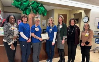 UH caregivers and leadership pose for photo during celebration.