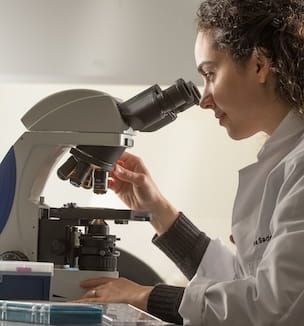 Thumbnail of a urology doctor looking into a microscope.