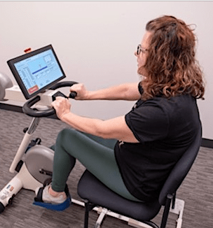 Thumbnail image of patient Mandy Ensman on an exercise bike.