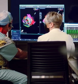 Thumbnail image of electrophysiologist and specialist looking at 3D heart mapping.