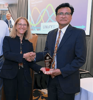 Thumbnail image of Dr. Charles Macias holding the Eisenberg Award.