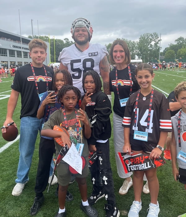Cleveland Browns player with pediatric patients at football training camp.