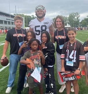 Thumbnail image of Browns player with pediatric patients.