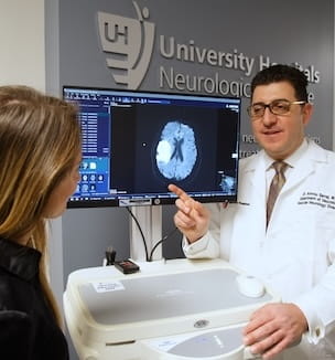 Thumbnail image of Dr. Amrou Sarraj showing a brain scan to Kelly Montgomery.