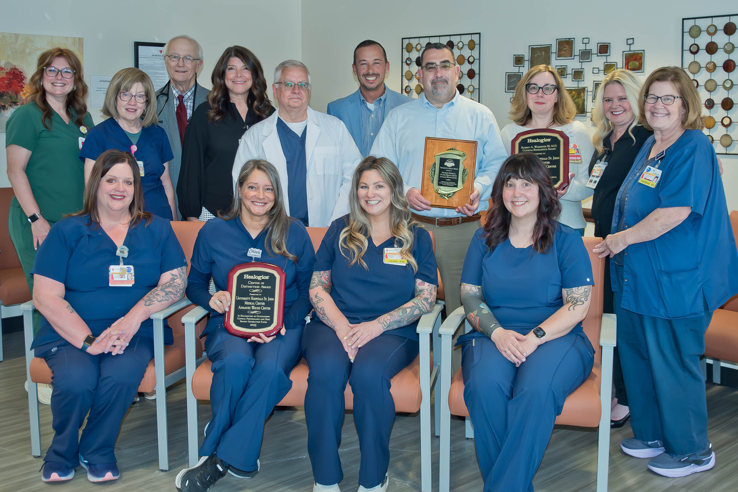 UH St. John caregivers gather for photo holding three award plaques.