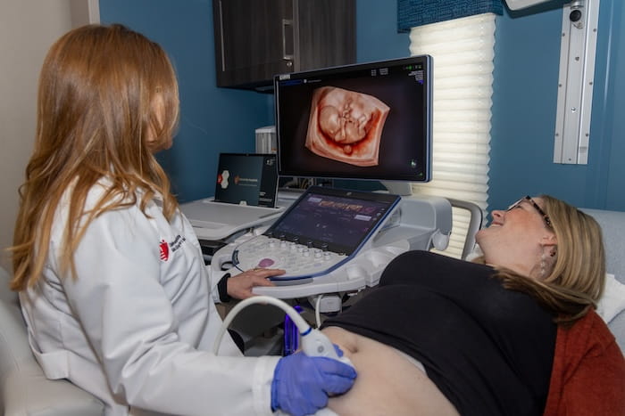 A female doctor performs an ultrasound on a pregnant patient.