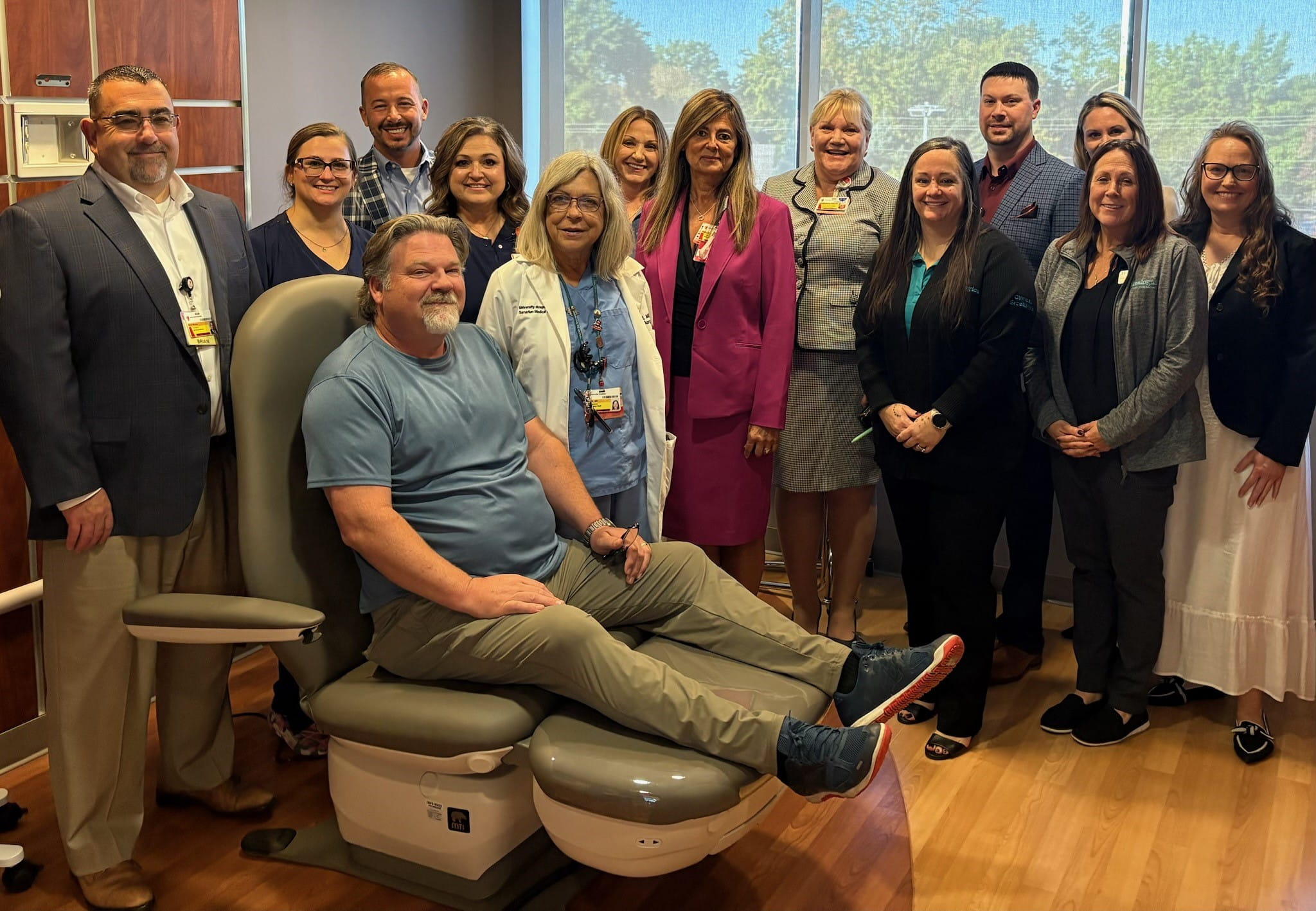 Seated patient poses with caregivers at UH Samaritan Wound Care Center.