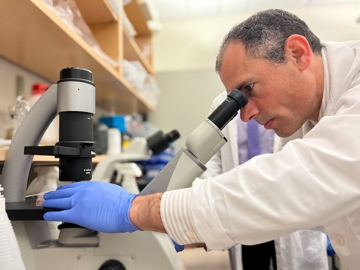 Dr. Jordan Winter of UH Seidman Cancer Center looks at tissue samples through a microscope.